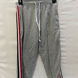 Gray sweat pants with red white and blue detailing on the side in a size small